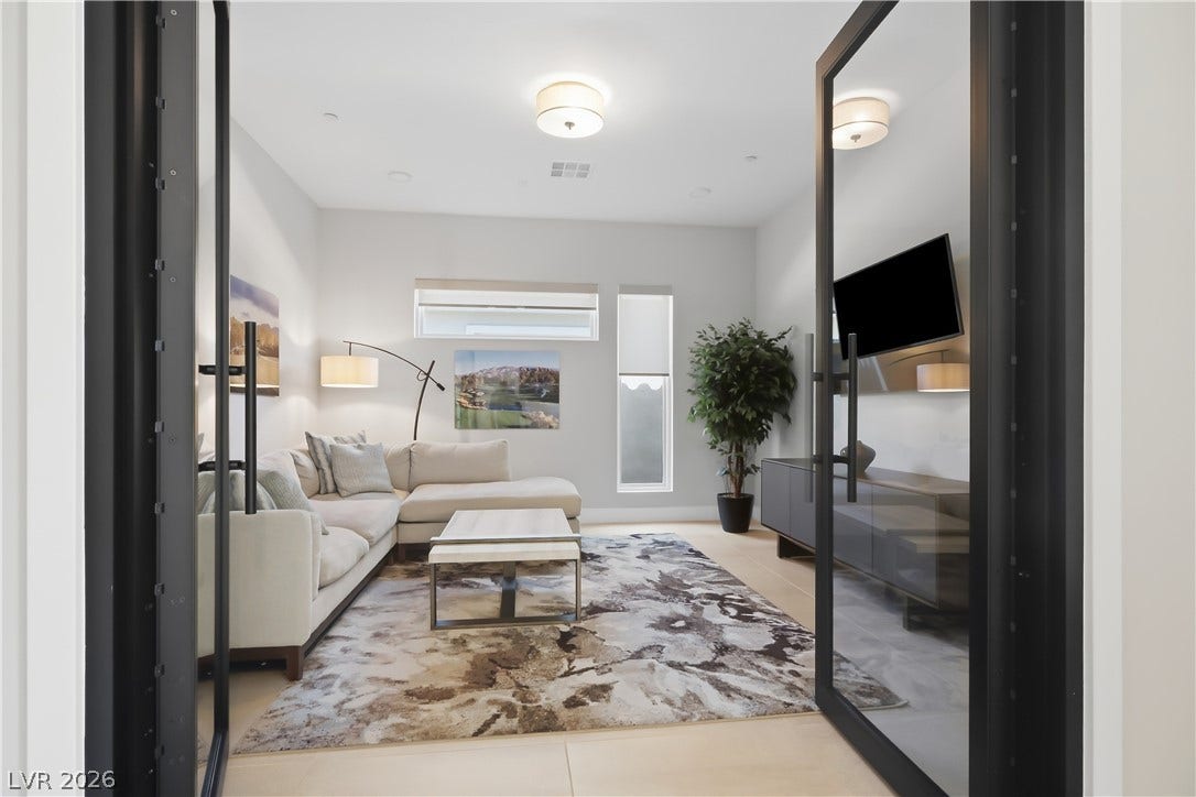 Double glass doors open into a modern living space featuring clean architectural lines.