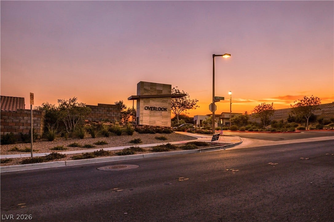 A welcoming neighborhood entry monument stands beautifully under a warm sunset sky.