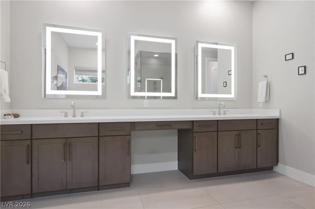 Clean lines and dual sinks define this modern vanity with integrated mirror lighting.