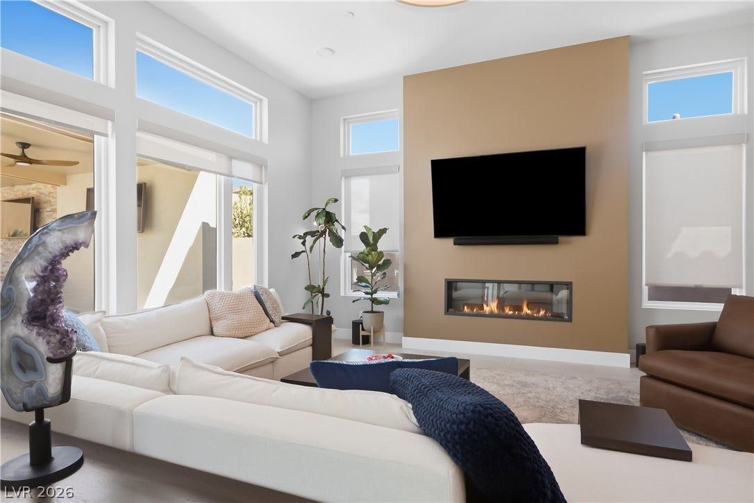 Soaring ceilings and a modern linear fireplace anchor this open gathering space.