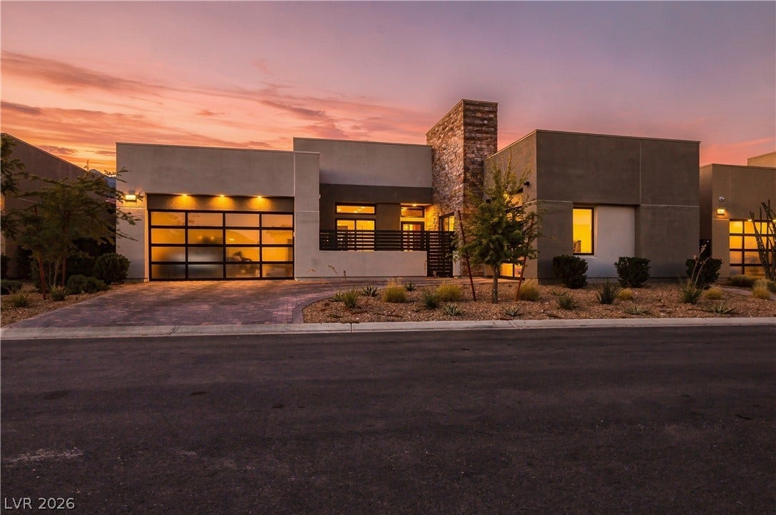 Clean architectural lines and stone accents define this modern single-story residence at sunset.