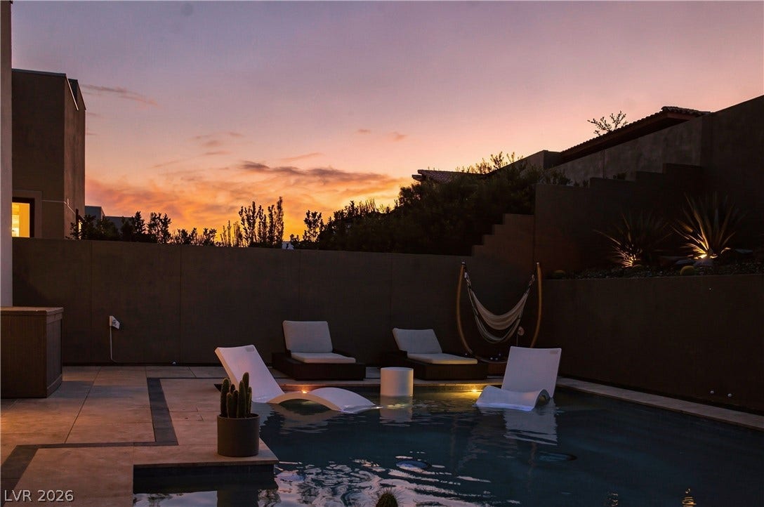 A private swimming pool and patio area bask in the warmth of a desert sunset.