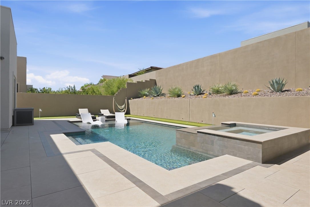 Clean lines and stone tiling frame a pristine private pool and adjacent spa.