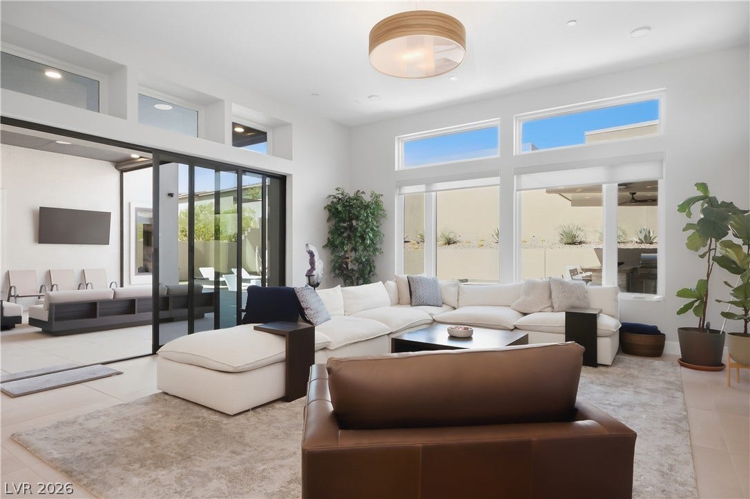 Soaring ceilings and massive sliding glass doors create a seamless indoor-outdoor living experience.