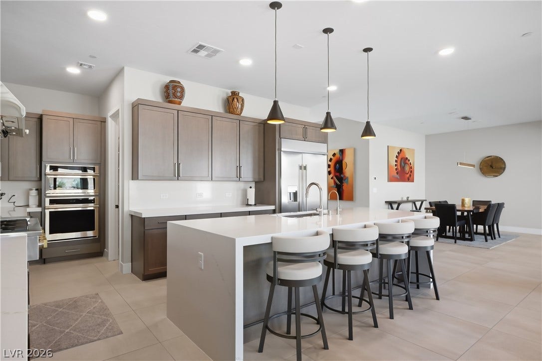 Smooth tiled flooring runs beneath a large center island in this open-concept kitchen space.