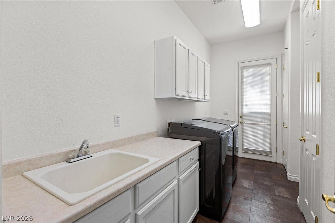 8088 Dark Hollow Place, Las Vegas, NV 89117 A dedicated laundry room features functional cabinetry and practical counter space for chores.