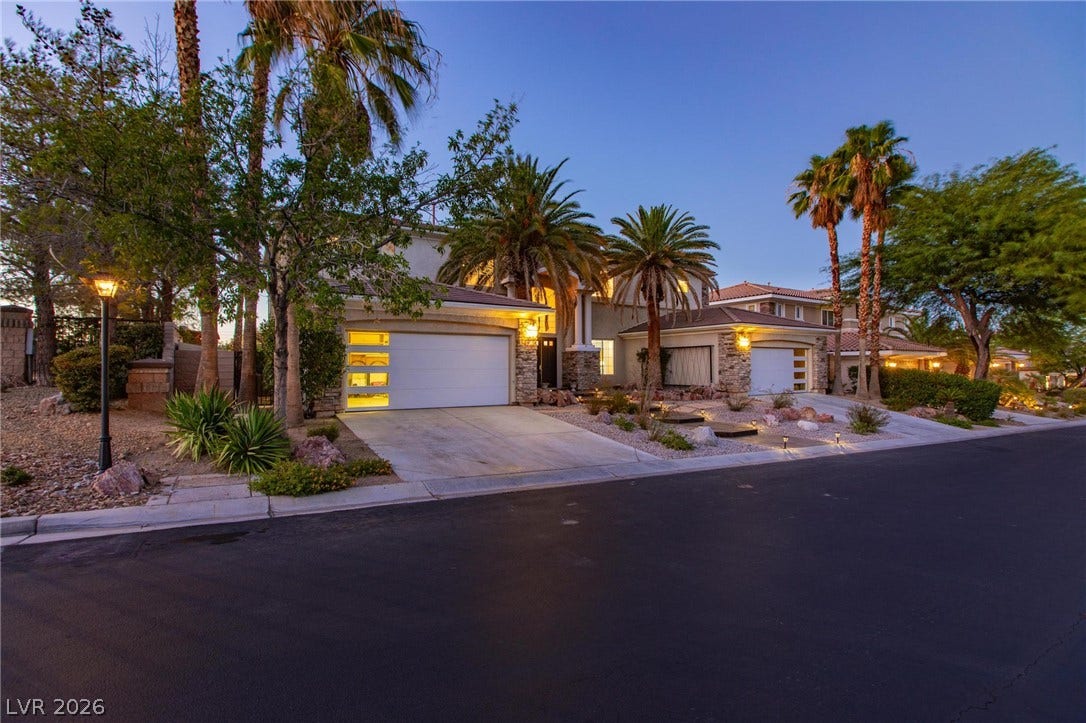 8088 Dark Hollow Place, Las Vegas, NV 89117 Stone accents and desert landscaping enhance this home's inviting curb appeal, illuminated by warm exterior lighting.