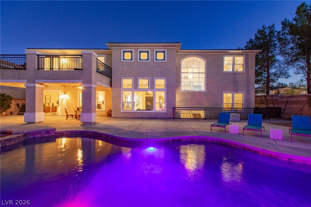8088 Dark Hollow Place, Las Vegas, NV 89117 An inviting exterior view reveals a captivating private pool and a spacious back of the structure, perfect for evening entertainment.