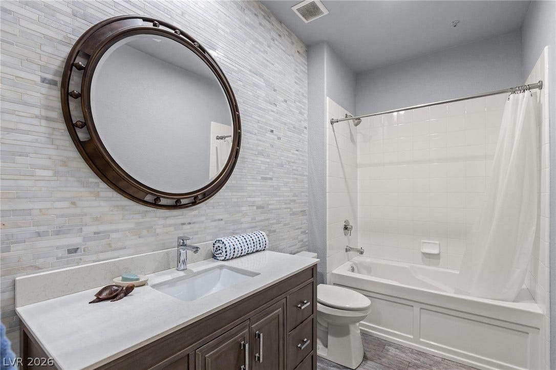 8088 Dark Hollow Place, Las Vegas, NV 89117 A well-appointed bathroom features a contemporary vanity, tile flooring, and a full shower-tub combination.