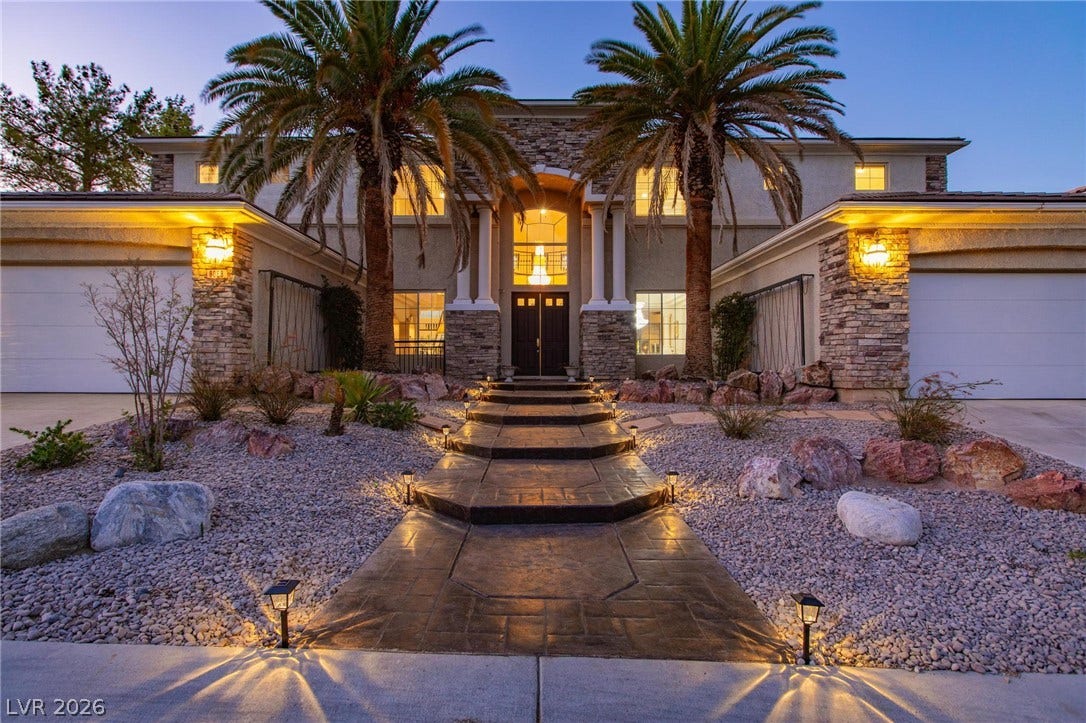 8088 Dark Hollow Place, Las Vegas, NV 89117 A grand entry beckons with a stately double door and path lighting, flanked by palm trees.