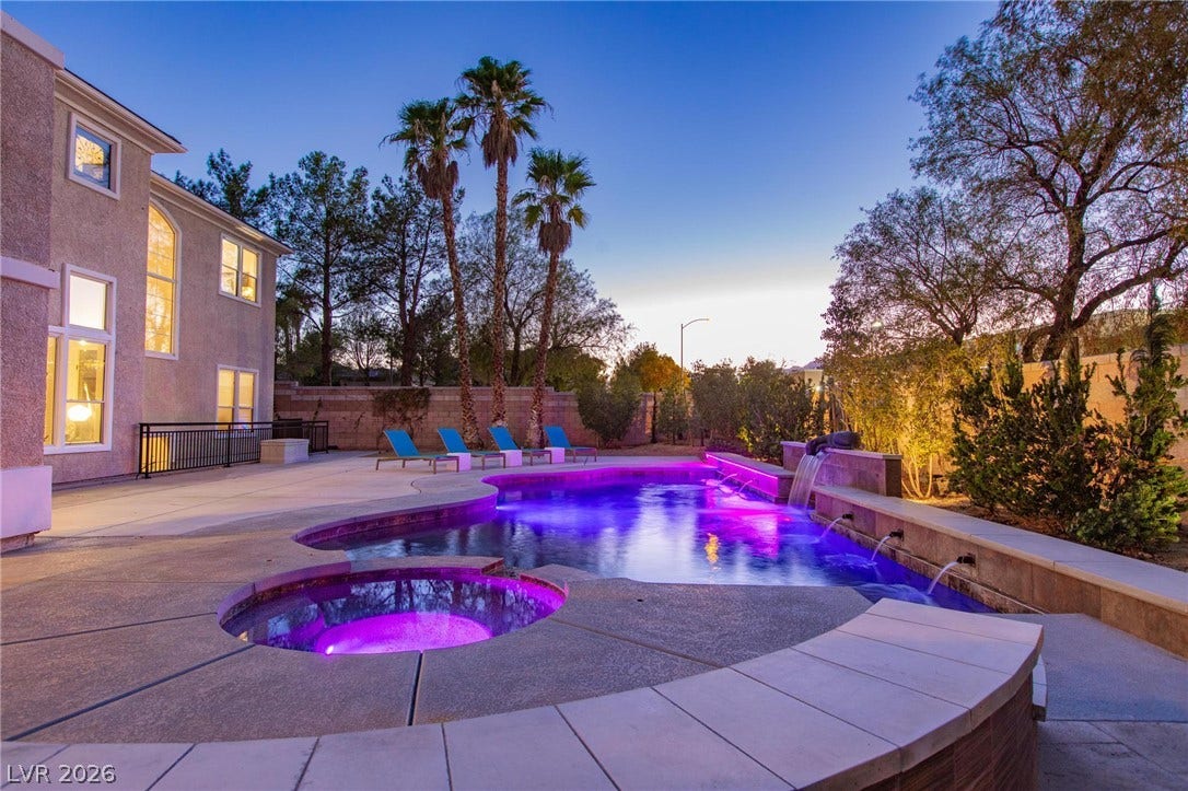 8088 Dark Hollow Place, Las Vegas, NV 89117 A serene twilight setting surrounds this private backyard oasis with an illuminated pool and integrated spa.