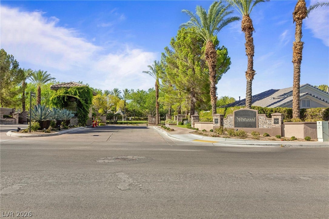 8088 Dark Hollow Place, Las Vegas, NV 89117 A well-maintained, gated community entrance featuring mature landscaping and a welcoming sign.