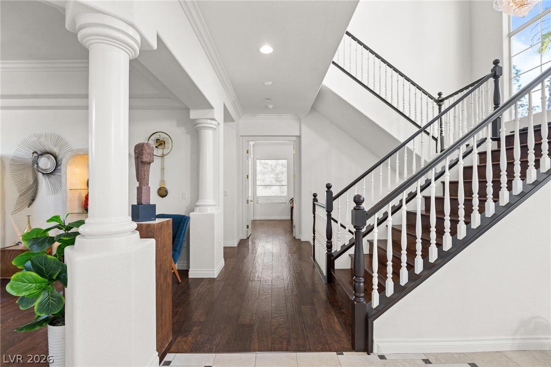 8088 Dark Hollow Place, Las Vegas, NV 89117 Grand entryway with dark wood flooring and a classic white and black staircase.