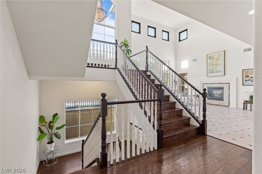 8088 Dark Hollow Place, Las Vegas, NV 89117 A grand double staircase with rich wood treads anchors this naturally illuminated, high-ceilinged entry foyer.