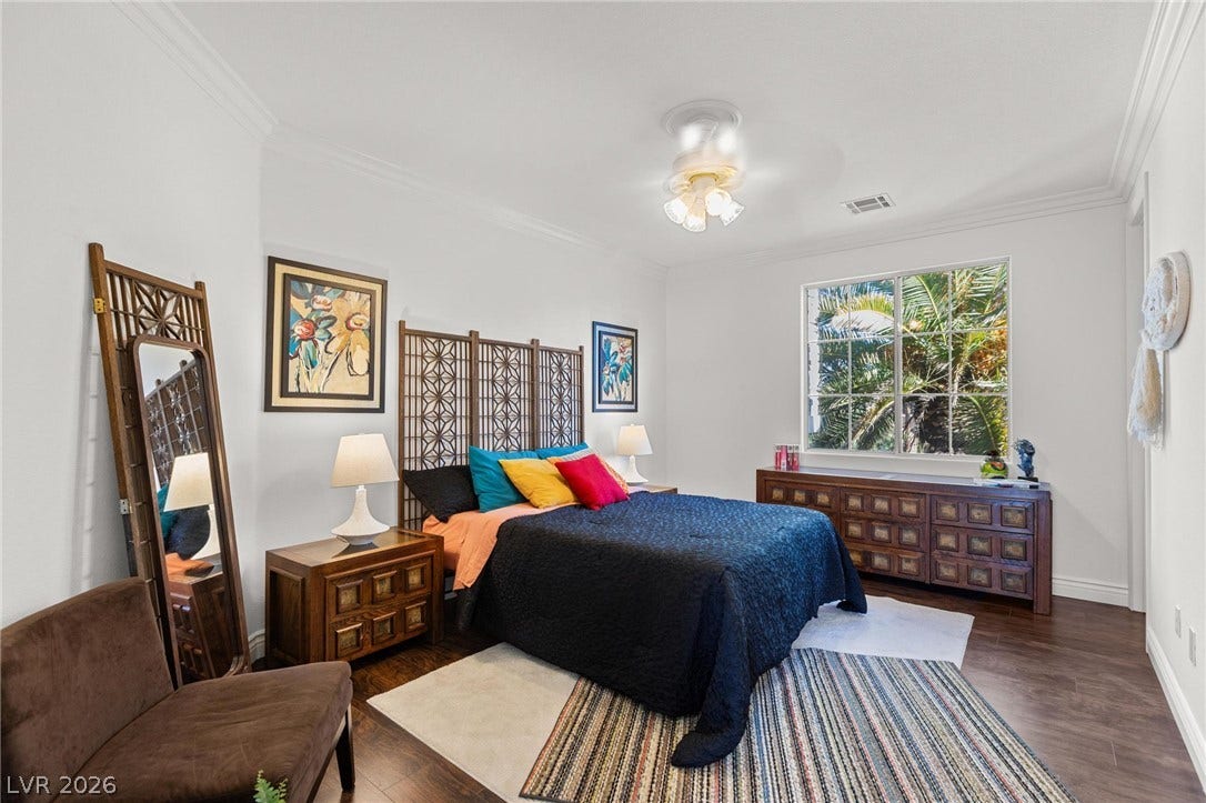 8088 Dark Hollow Place, Las Vegas, NV 89117 Hardwood floors and a wide window with a lush green view enhance this tranquil bedroom's ambiance.