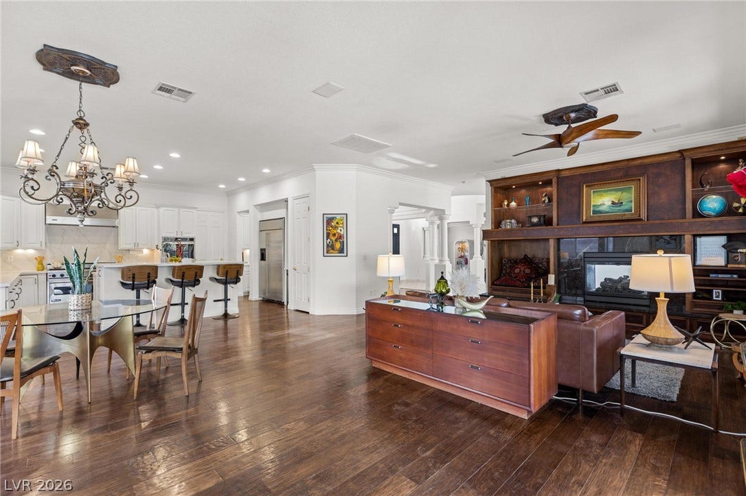8088 Dark Hollow Place, Las Vegas, NV 89117 Rich hardwood floors unite the open-concept kitchen and living area, complete with a built-in entertainment center and elegant dining space.