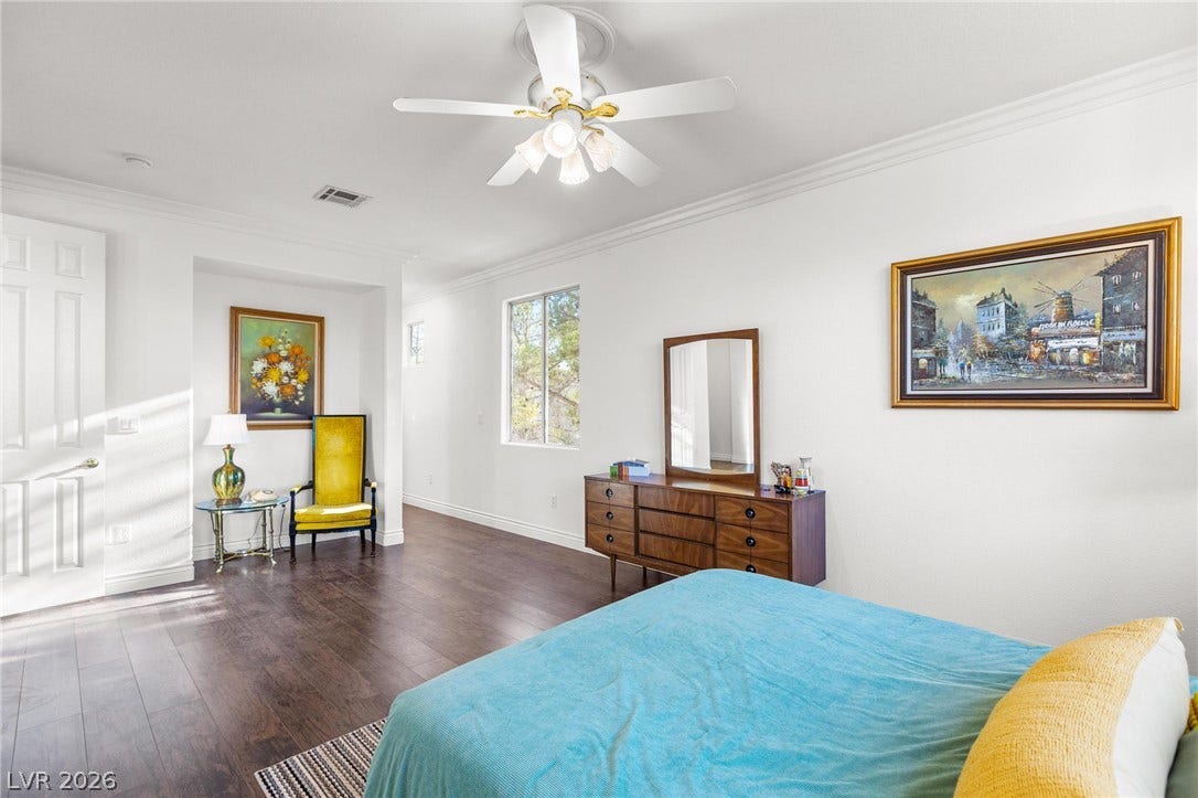 8088 Dark Hollow Place, Las Vegas, NV 89117 Hardwood flooring and a refreshing ceiling fan create an inviting atmosphere within this generous sleeping space.