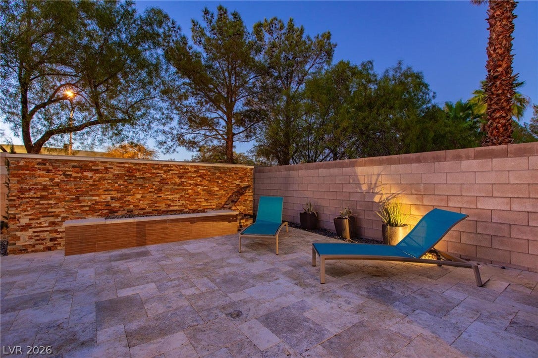 8088 Dark Hollow Place, Las Vegas, NV 89117 An inviting outdoor patio features attractive stone flooring and built-in seating for relaxation.
