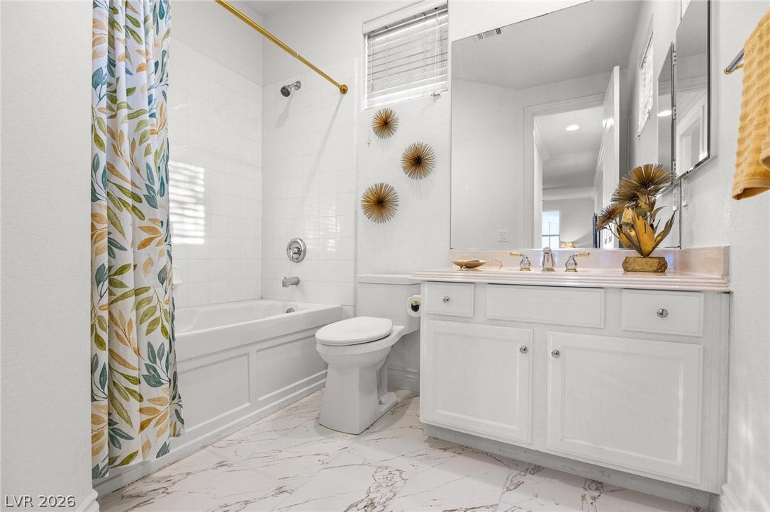 8088 Dark Hollow Place, Las Vegas, NV 89117 White subway tile surrounds the tub in this well-appointed bath with a marble-topped vanity.