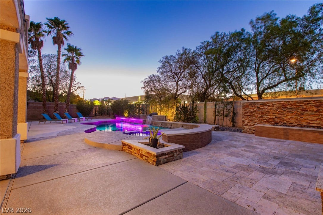 8088 Dark Hollow Place, Las Vegas, NV 89117 An inviting backyard oasis offers a vibrant pool, integrated spa, and expansive paved patio for relaxed entertaining.