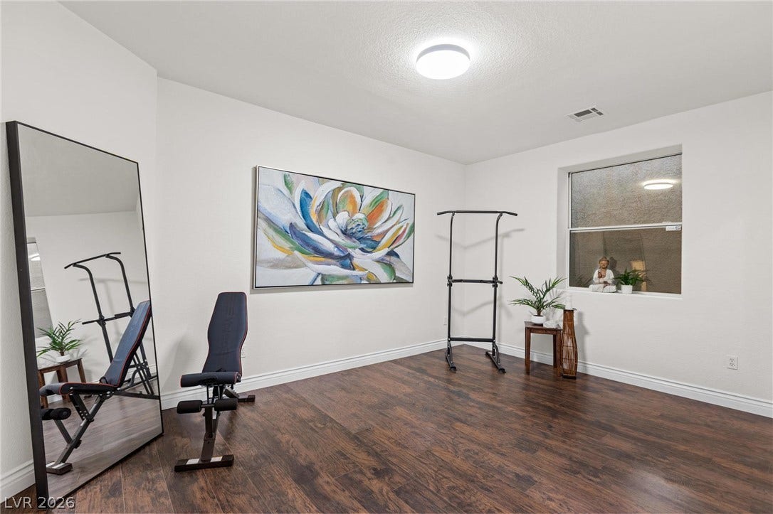8088 Dark Hollow Place, Las Vegas, NV 89117 Rich hardwood floors complement this versatile room, perfect for a dedicated exercise space or creative studio.