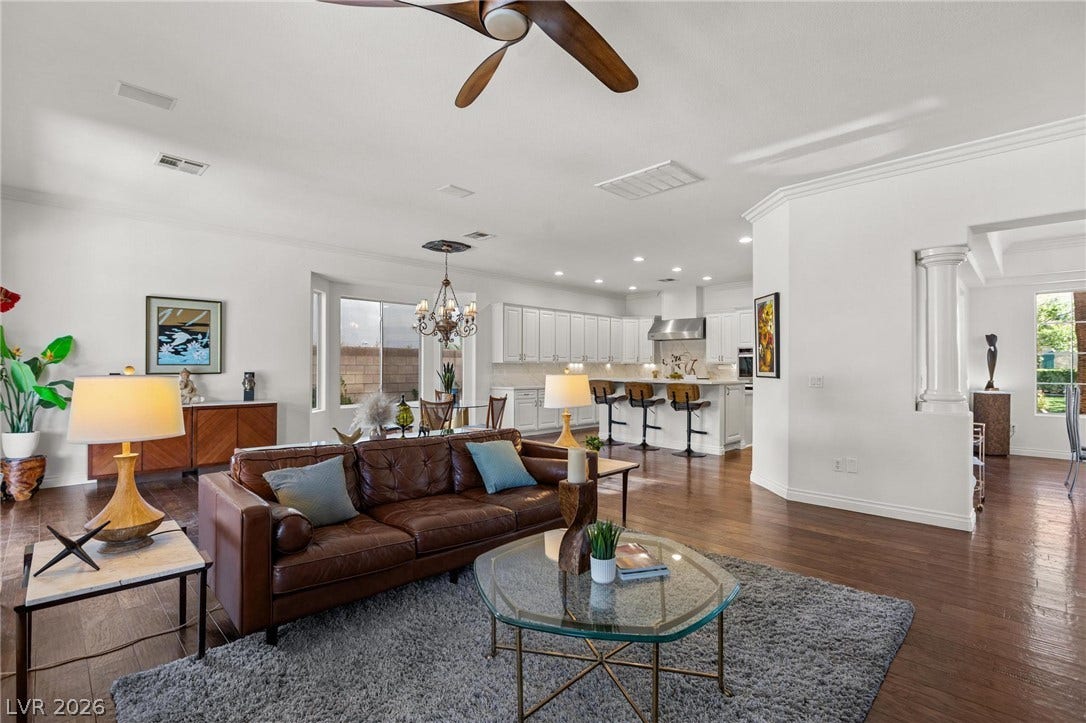 8088 Dark Hollow Place, Las Vegas, NV 89117 An inviting open-concept living space features warm hardwood floors and a well-appointed kitchen beyond.