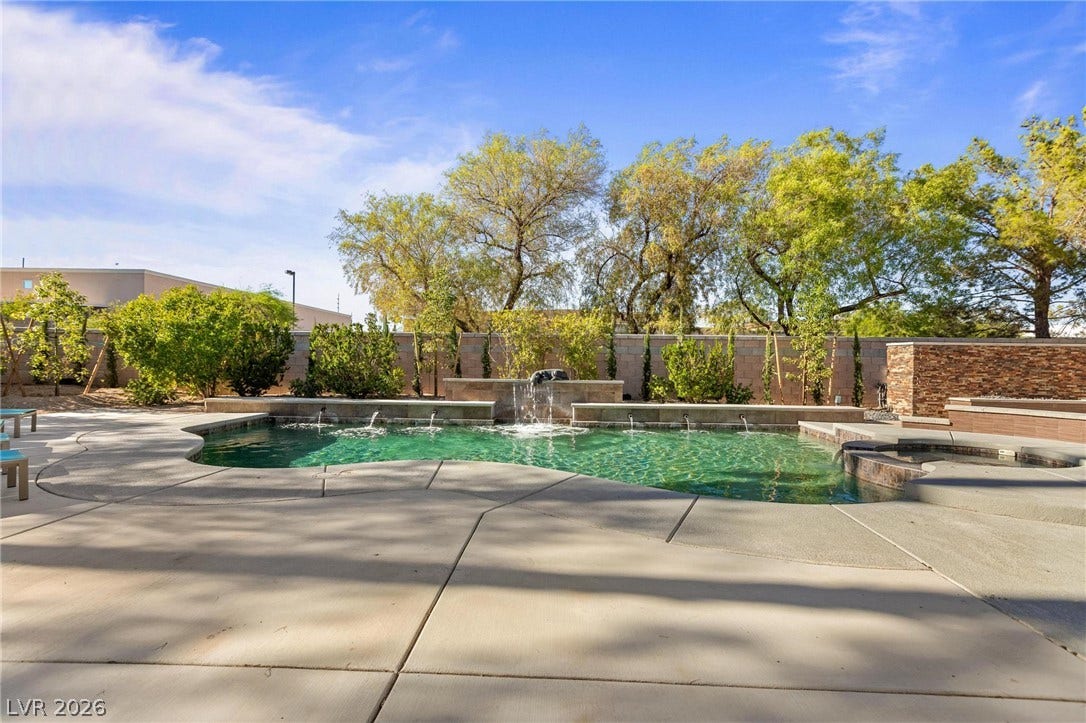 8088 Dark Hollow Place, Las Vegas, NV 89117 A tranquil oasis awaits with this private pool featuring a waterfall and surrounding patio.
