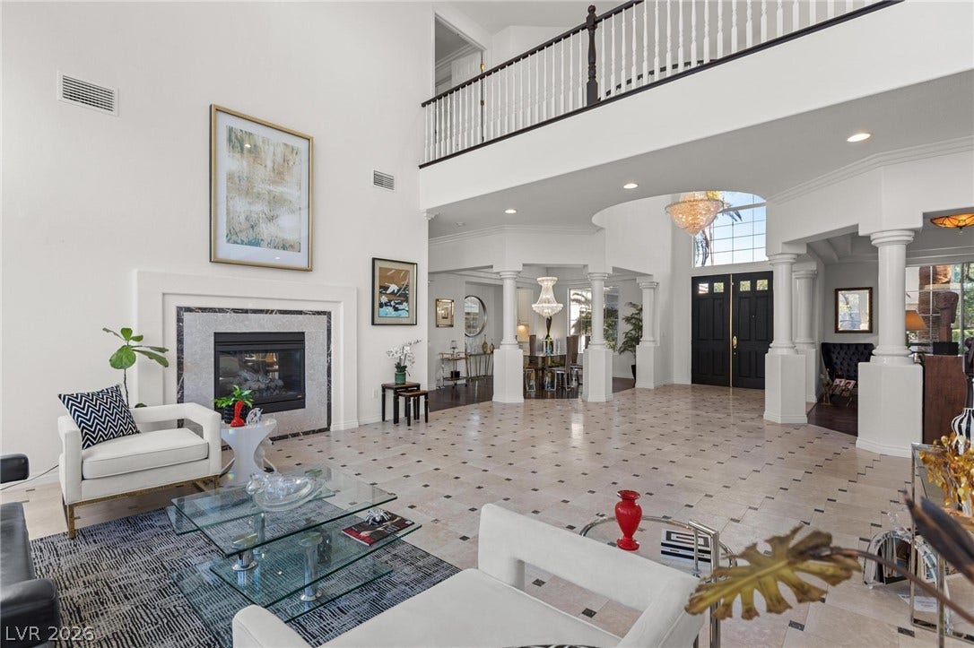 8088 Dark Hollow Place, Las Vegas, NV 89117 A grand entrance welcomes guests with soaring ceilings, a striking fireplace, and an elegant second-story balcony.