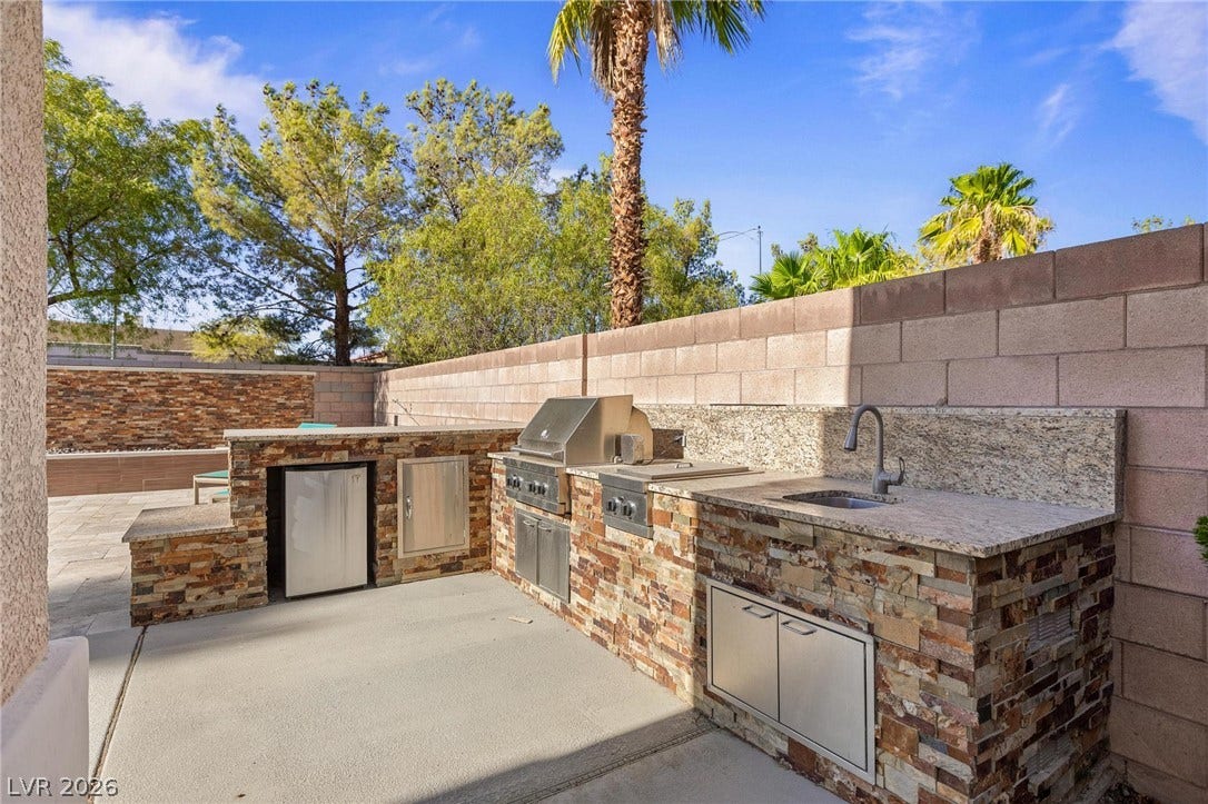8088 Dark Hollow Place, Las Vegas, NV 89117 An outdoor kitchen crafted from stacked stone and granite offers an ideal setting for entertaining.