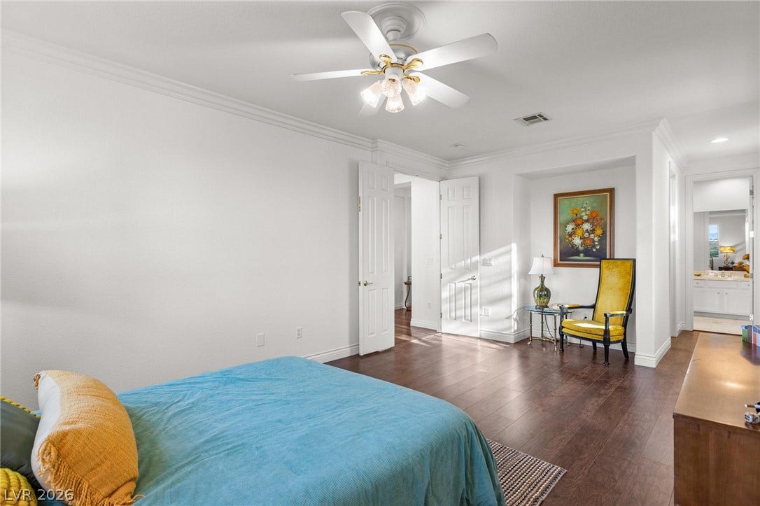 8088 Dark Hollow Place, Las Vegas, NV 89117 Rich wood flooring and ample natural light define this inviting bedroom, offering a comfortable retreat.