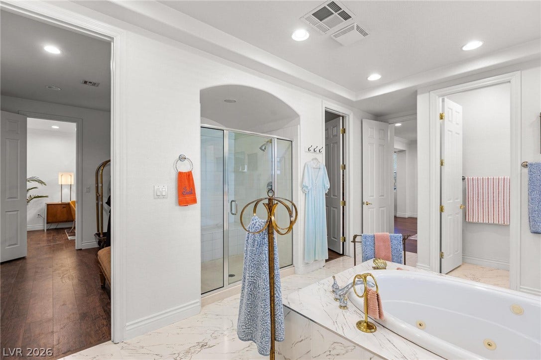 8088 Dark Hollow Place, Las Vegas, NV 89117 Luxurious bathing retreat boasts a deep soaking tub and a spacious glass-enclosed shower.