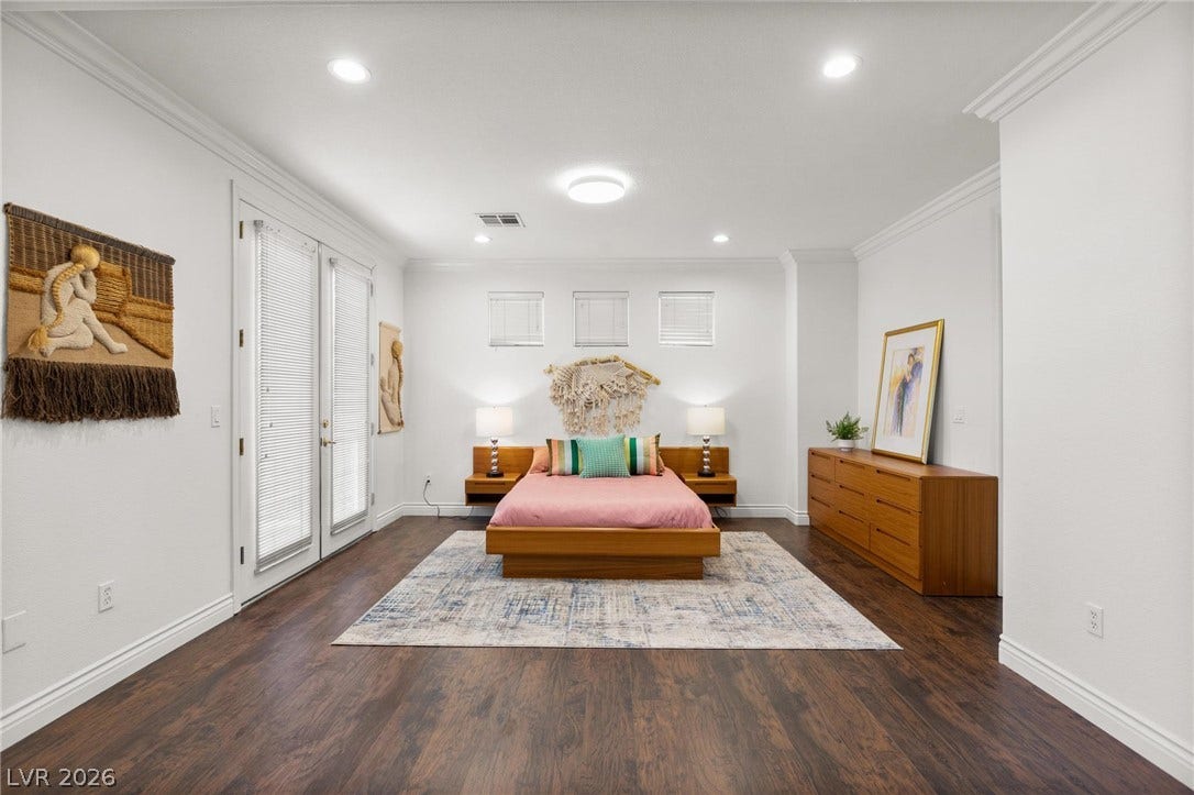 8088 Dark Hollow Place, Las Vegas, NV 89117 Discover a tranquil primary bedroom sanctuary with rich wood flooring and crisp white crown molding.