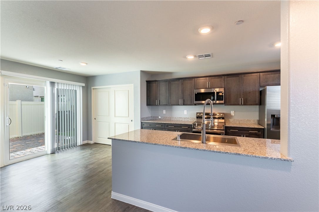 6911 Orange Horizon Street, North Las Vegas, NV 89086 An open layout kitchen flows effortlessly into the dining area with direct patio access.