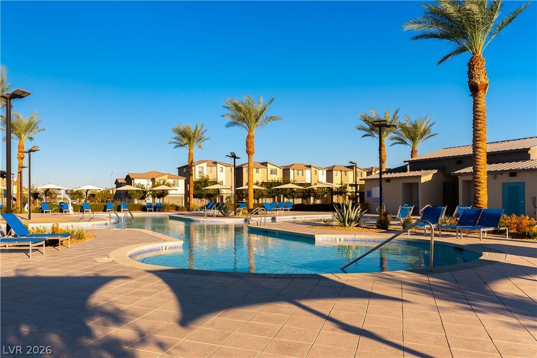 6911 Orange Horizon Street, North Las Vegas, NV 89086 A spacious tiled deck surrounds the community swimming pool under towering palm trees.