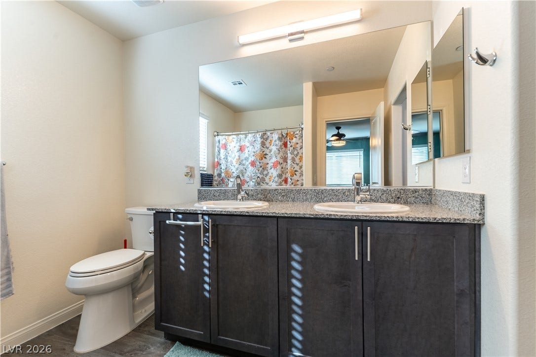 6911 Orange Horizon Street, North Las Vegas, NV 89086 A spacious vanity with granite counters anchors this modern bathroom.