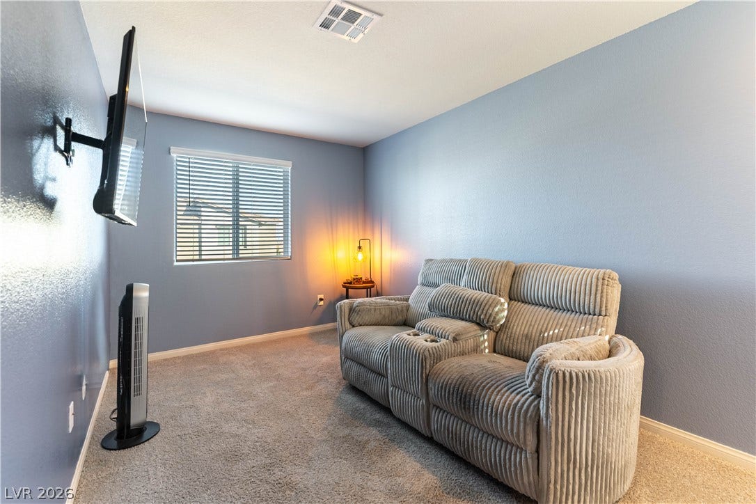 6911 Orange Horizon Street, North Las Vegas, NV 89086 Plush wall-to-wall carpeting and a bright window define this versatile media room.