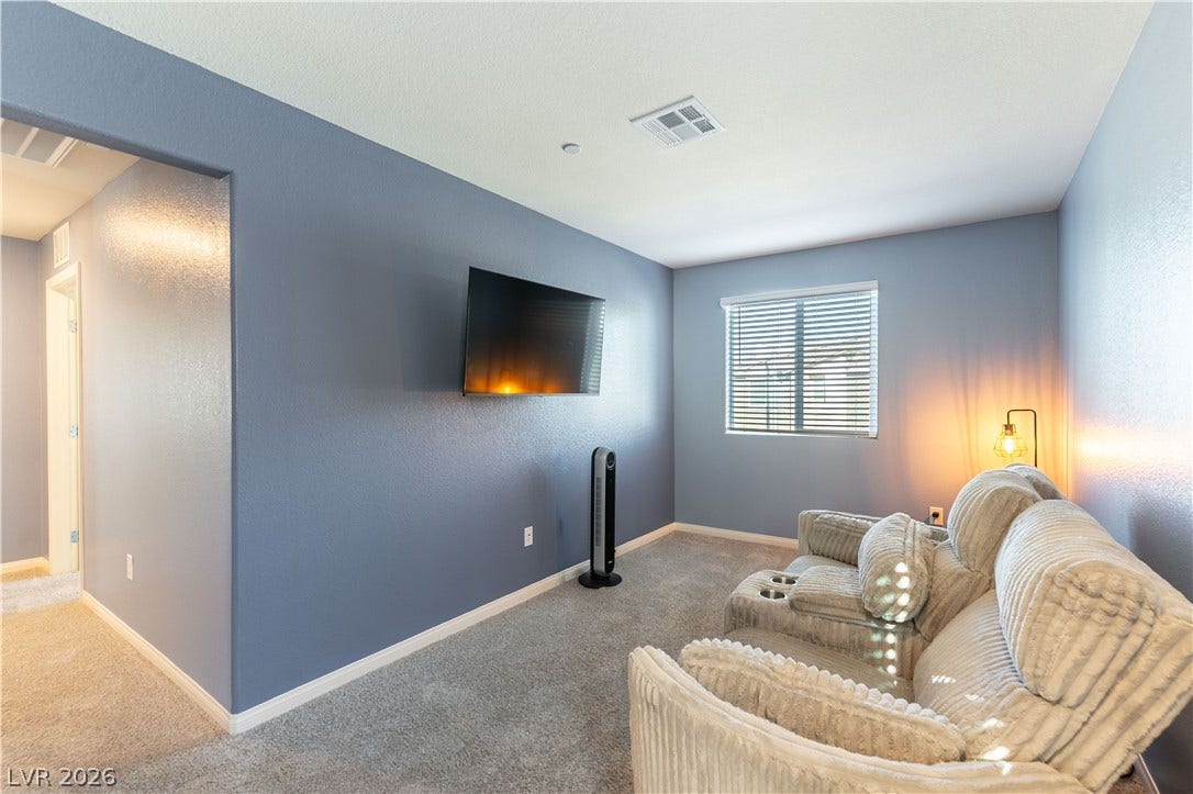 6911 Orange Horizon Street, North Las Vegas, NV 89086 Smooth plaster walls and soft carpeting define this versatile living space.
