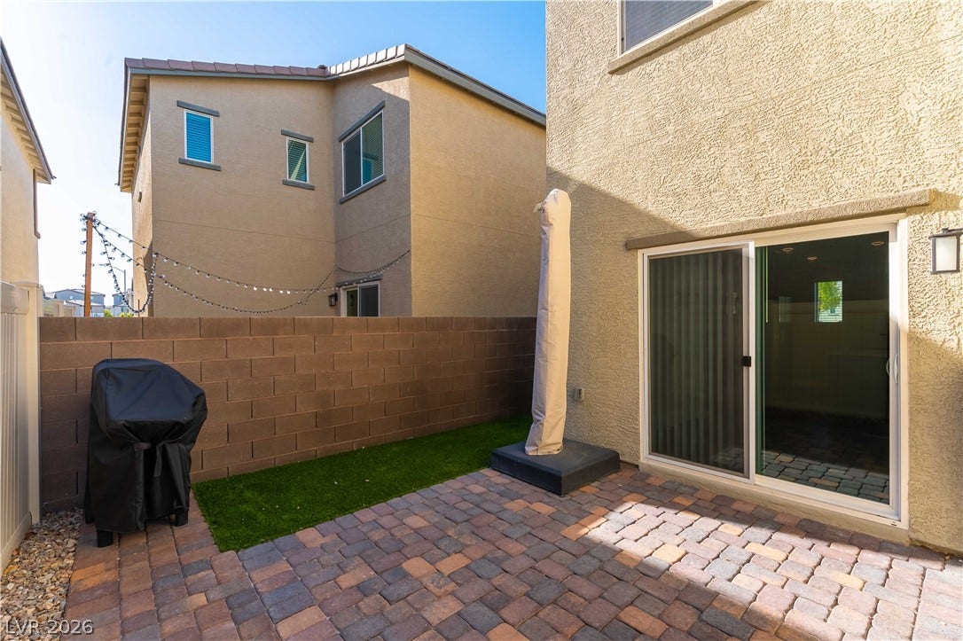 6911 Orange Horizon Street, North Las Vegas, NV 89086 An inviting paver stone patio bordered by a low block wall and manicured lawn.