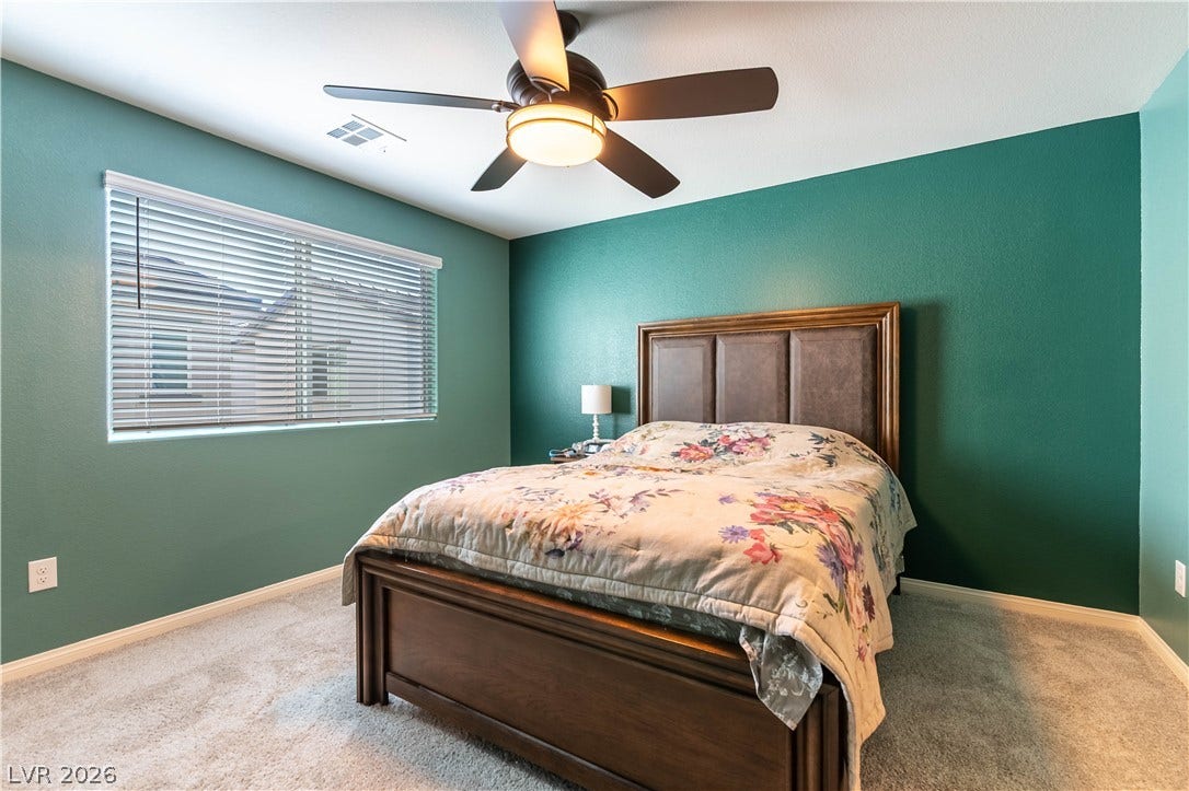 6911 Orange Horizon Street, North Las Vegas, NV 89086 Richly textured carpet and a wide window with integrated blinds frame this restful space.