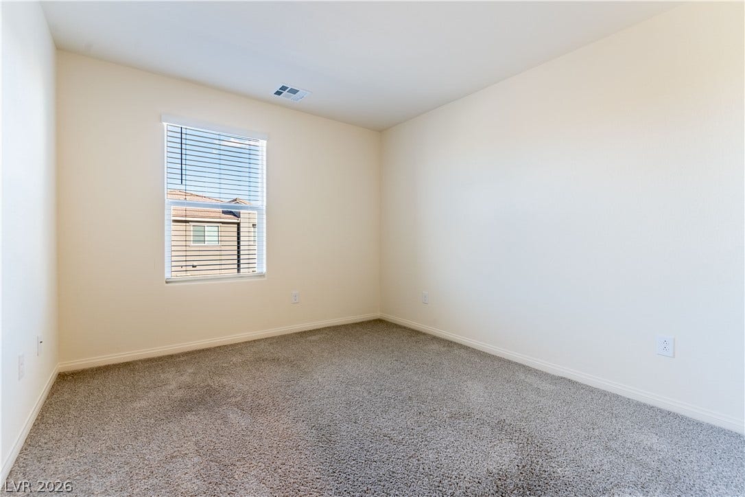 6911 Orange Horizon Street, North Las Vegas, NV 89086 Plush wall-to-wall carpeting and neutral tones define this versatile secondary bedroom space.