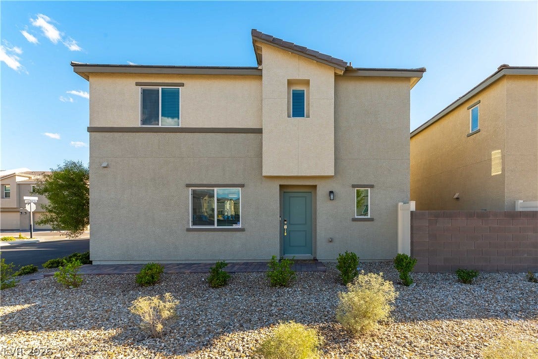 6911 Orange Horizon Street, North Las Vegas, NV 89086 Modern desert landscaping frames this contemporary two-story home under clear blue skies.