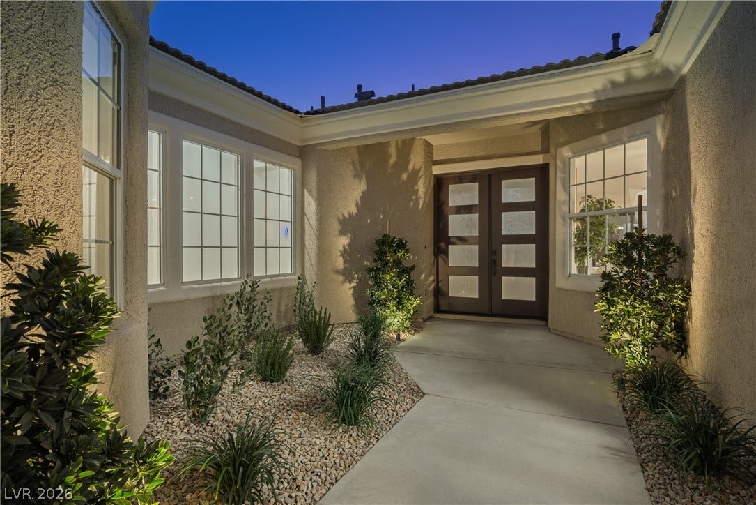 10248 Andante Court, Las Vegas, NV 89135 Exterior entry at night featuring french doors, stucco siding, and a tile roof