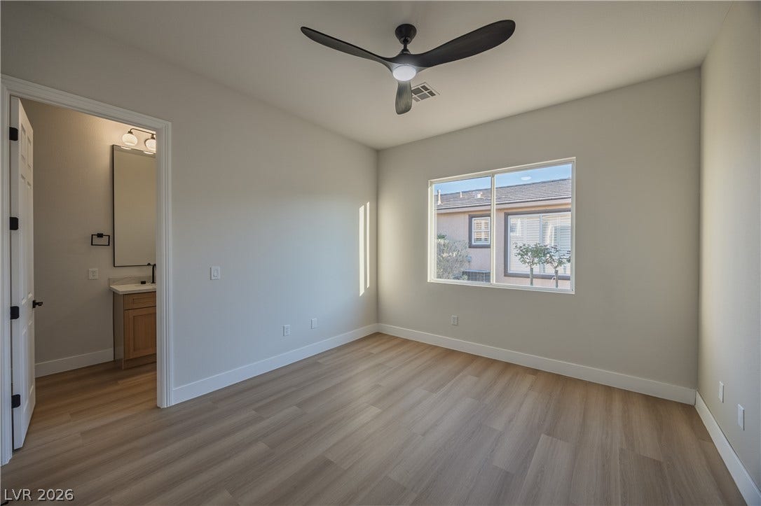10248 Andante Court, Las Vegas, NV 89135 Unfurnished bedroom featuring light wood-style floors, a ceiling fan, and connected bathroom