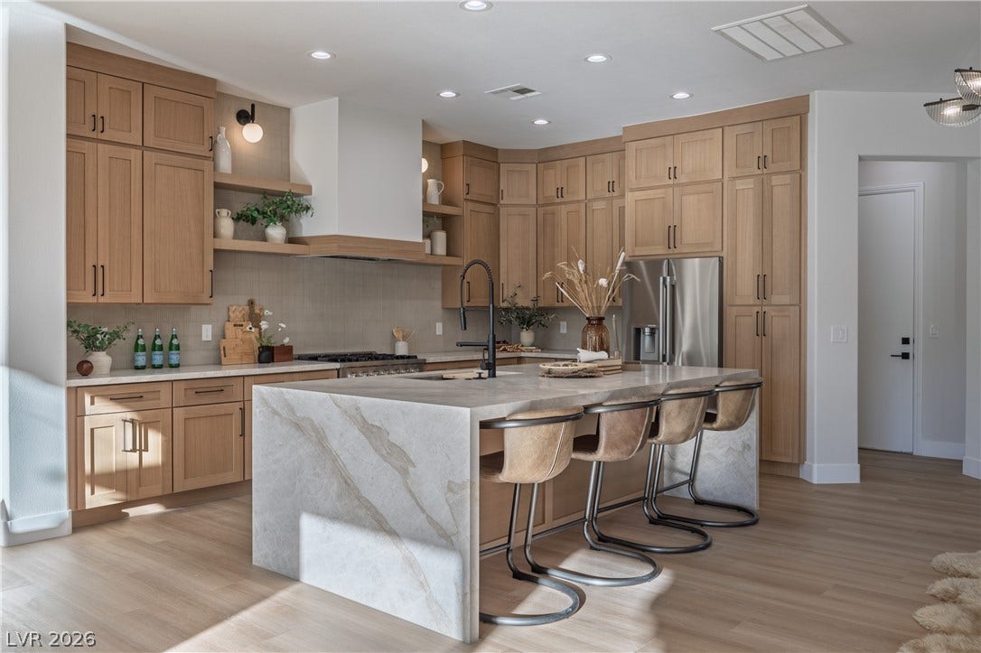 10248 Andante Court, Las Vegas, NV 89135 Kitchen with a breakfast bar area, open shelves, light stone countertops, light wood-style floors, and stainless steel refrigerator with ice dispenser