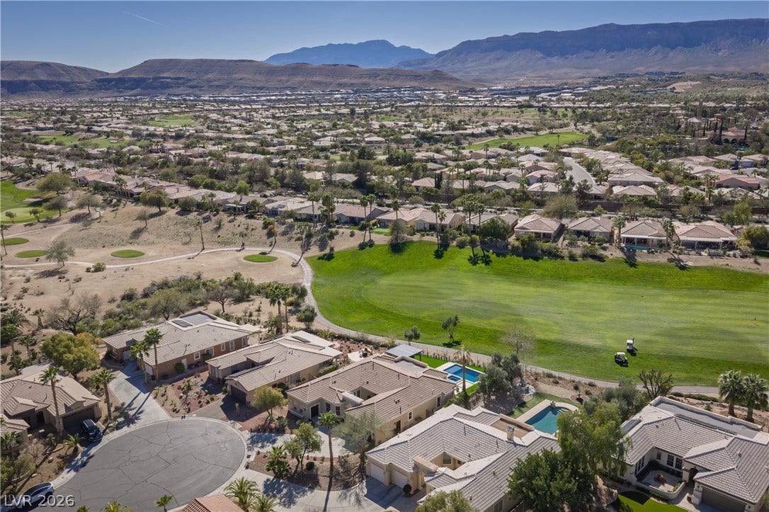 10248 Andante Court, Las Vegas, NV 89135 Aerial perspective of suburban area with mountains and a golf club