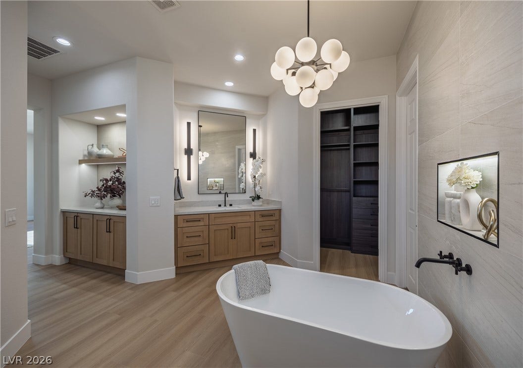 10248 Andante Court, Las Vegas, NV 89135 Full bathroom featuring vanity, a freestanding bath, hanging lights, light wood finished floors, and tile walls