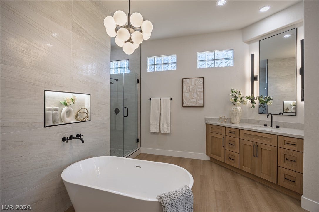 10248 Andante Court, Las Vegas, NV 89135 Bathroom with vanity, a soaking tub, a shower stall, light wood-style floors, and hanging lights