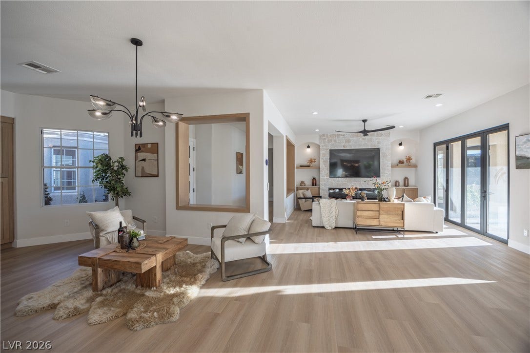 10248 Andante Court, Las Vegas, NV 89135 Living area with light wood-style flooring, a chandelier, and ceiling fan