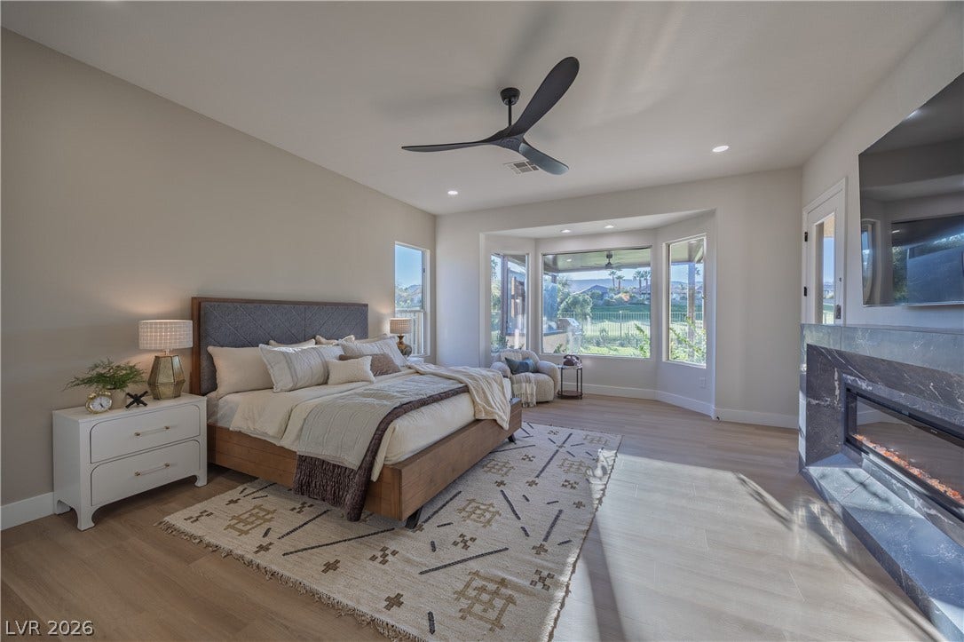 10248 Andante Court, Las Vegas, NV 89135 Bedroom with light wood-style flooring, ceiling fan, a high end fireplace, and recessed lighting