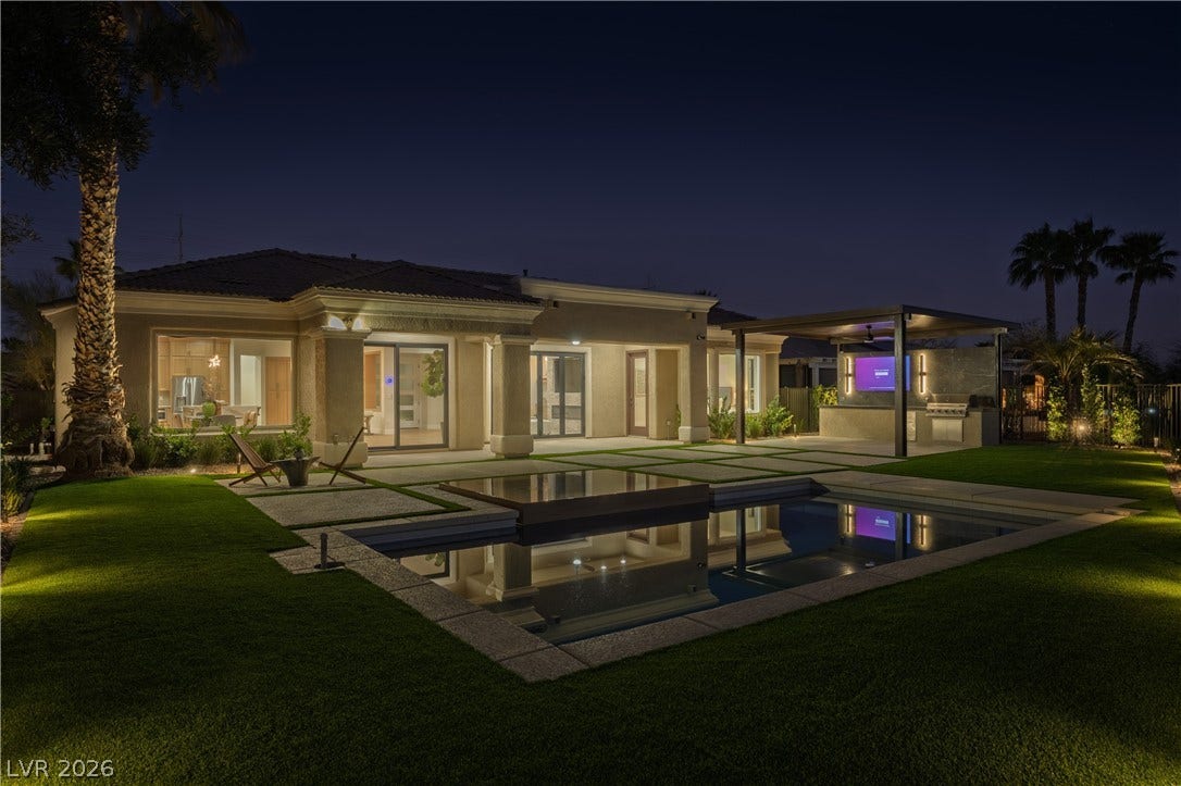 10248 Andante Court, Las Vegas, NV 89135 Back of house at night with a lawn, an outdoor pool, and a patio